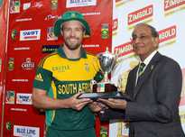 South Africa captain AB de Villiers receives the series trophy from Haroon Lorgat.